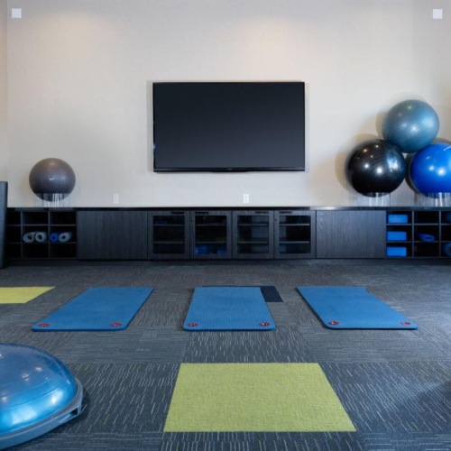 a yoga studio with a tv and mats